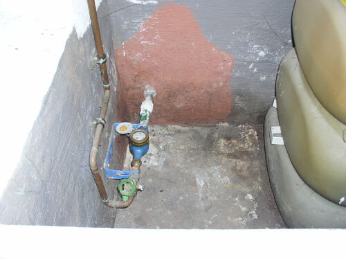 Diese "Auffangwanne" ist sicher undicht und die Wasserrohre haben da nichts zu suchen.
