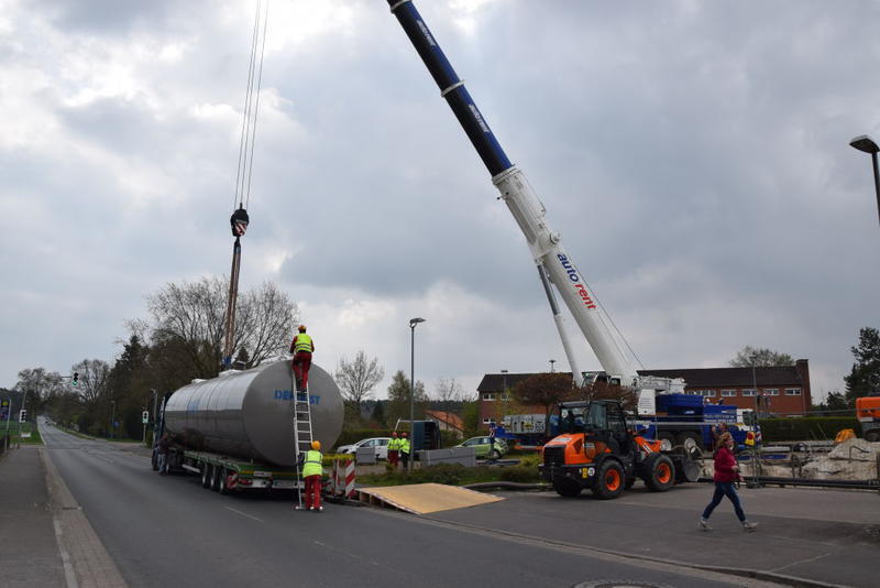 Ein Dehoust Tank wird mit einem Kran auf einen Tieflader verladen.